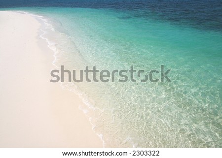 Beach Paradise-Clear blue water lapping gently on a white sandy beach on Rawa Island, Malaysia