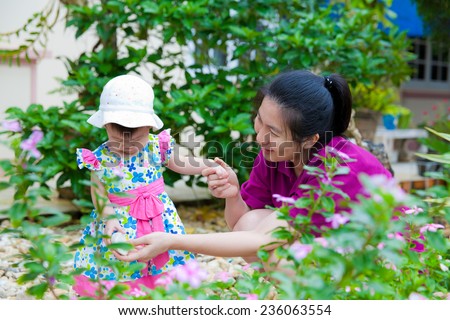 Happy asian woman and little girl relaxing at home back yard and sun light in holiday
