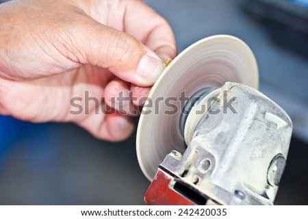 Human hand using grinder, power tool used for cutting, grinding and polishing
