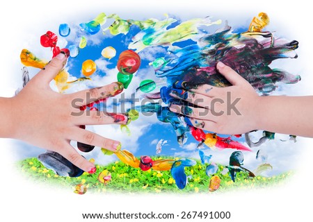 Closeup of little children hands doing finger painting with various colors on sky and green clover background. Use it for creative or imagination concept, top view