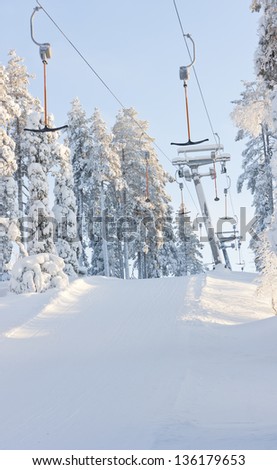 Ski elevators of lifts between snowy forest in ski resort at winter