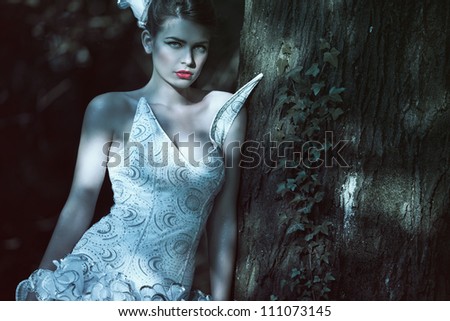 attractive girl in the original wedding gown, standing in the forest