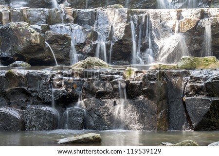 Small water fall with big rocks that have not much water in this season