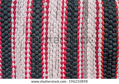 Old door mat or foot scraper with stripe of red and black