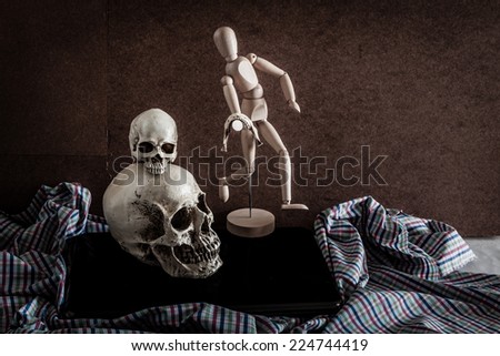 Still life of skull,wooden figure, old vintage camera and notebook on fabric.vintage color