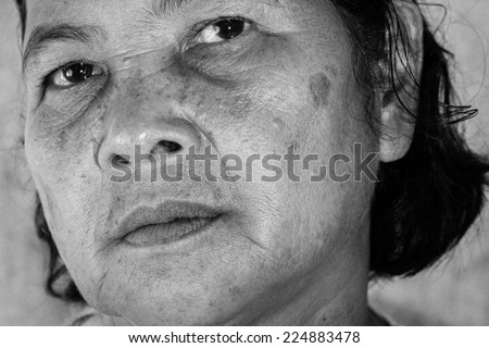 Close up portrait of 60 years old Thai woman in black and white