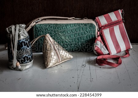 Old small wallets on white table and brown wooden background