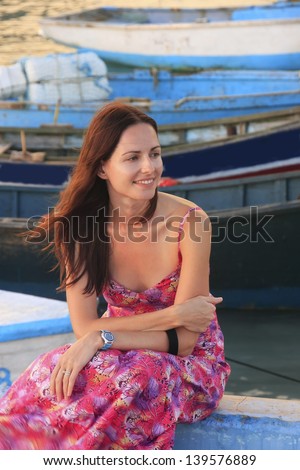 Young woman sitting at Boca Chica boat pier, Dominican Republic