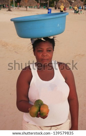 BOCA CHICA, DOMINICAN REPUBLIC-DECEMBER 9: An unidentified woman sells fruits on December 9, 2012 at Boca Chica, Dominican Republic. Boca Chica is the most crowded beach in Dominican Republic.