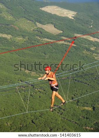 CRIMEA, UKRAINE-SEPTEMBER 3: An unidentified rock climber walks on a rope on September 3, 2012 at Ai-Petri summit, Crimea, Ukraine. Ai-Petri is one of the peaks of Crimean Mountains over 1200 m.