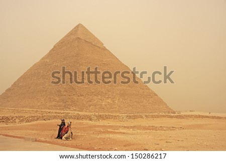 CAIRO, EGYPT-DECEMBER 11: Unidentified man rest near Pyramid of Khafre on December 11, 2010 in Cairo, Egypt. Great Pyramids are the oldest of the ancient Wonders and the only one still in existence.