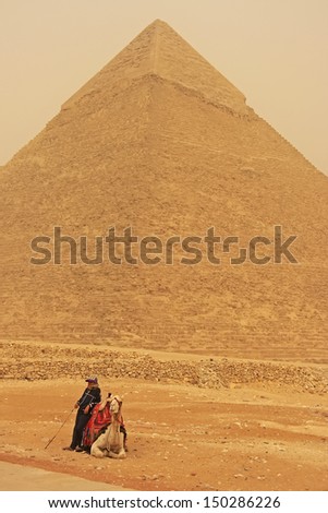 CAIRO, EGYPT-DECEMBER 11: Unidentified man rest near Pyramid of Khafre on December 11, 2010 in Cairo, Egypt. Great Pyramids are the oldest of the ancient Wonders and the only one still in existence.