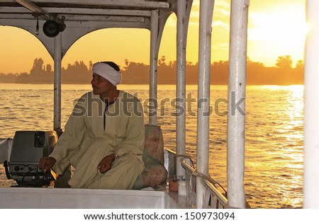 LUXOR, EGYPT - DECEMBER 23: An unidentified man drives his boat on the Nile river at sunset on December 23, 2010 in Luxor, Egypt. Nile river is generally regarded as the longest river in the world.