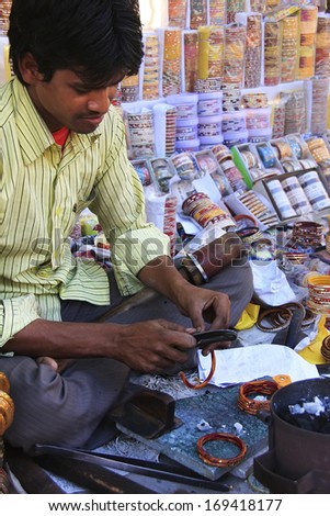 BUNDI, INDIA-FEBRUARY 4: An unidentified man fixes bracelets at market on February 4, 2011 in Bundi, India. Bundi is a popular place of attraction and tourism industry primarily supports its economy