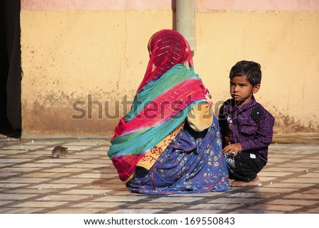 DESHNOK, INDIA - FEBRUARY 21: Unidentified woman and unidentified boy sit at Karni Mata Temple on February 21, 2011 in Deshnok, India. Over 20000 holy rats live in Karni Mata Temple.