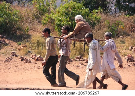 RANTHAMBORE, INDIA-FEBRUARY 2: Unidentified men carry unidentified woman on February 2,2011 in Ranthambore Fort, India. It is one of six forts included in World Heritage Site 
