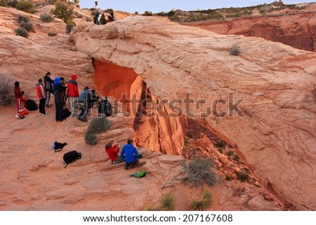 UTAH, USA - MARCH 29: Unidentified people watch sunrise at Mesa Arch on March 29, 2013 in Canyonlands National Park, USA. Canyonlands  is a popular recreational destination all year around.