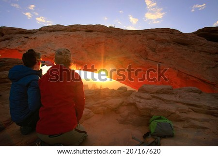 UTAH, USA - MARCH 29: Unidentified women watch sunrise at Mesa Arch on March 29, 2013 in Canyonlands National Park, USA. Canyonlands  is a popular recreational destination all year around.