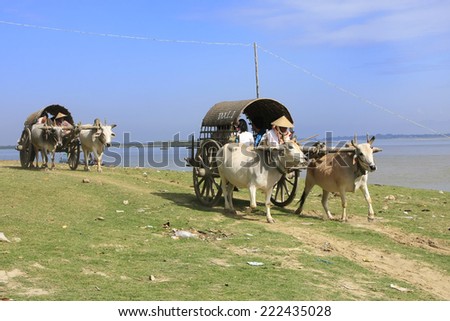 MINGUN, MYANMAR - DECEMBER 30: Unidentified people take ox carts along the river on December 30, 2011 in Mingun, Myanmar. Mingun is a popular boat trip for foreign tourists from Mandalay.
