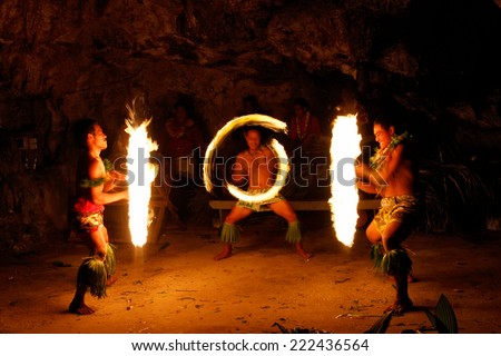 TONGATAPU, TONGA - NOVEMBER 13: Unidentified men perform fire dance (blurred motion) in Hina cave on November 13, 2013 in Tongtapu, Tonga. Famous Hina cave is a big tourist attraction on Tongatapu.