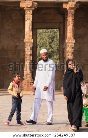 DELHI, INDIA-NOVEMBER 4: Unidentified man, woman and kids walk in Quwwat-Ul-Islam mosque courtyard at Qutub Minar complex on November 4, 2014 in Delhi, India. Qutub Minar is the tallest minar in India