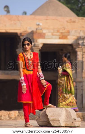 DELHI, INDIA - NOVEMBER 4: Unidentified woman with unidentified child drinks water at Qutub Minar complex on November 4, 2014 in Delhi, India. Qutub Minar is the tallest minar in India