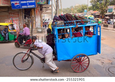DELHI, INDIA - NOVEMBER 5: Unidentified kids take cycle rickshaw to school on November 5, 2014 in Delhi, India. Cycle rickshaws are a popular mode of travel for short distance transits in the city.