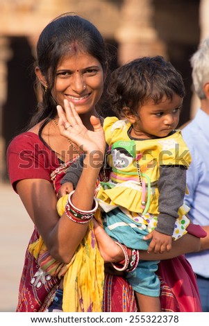 DELHI, INDIA - NOVEMBER 4: Unidentified woman with unidentified child stands in mosque courtyard at Qutub Minar complex on November 4, 2014 in Delhi, India. Qutub Minar is the tallest minar in India