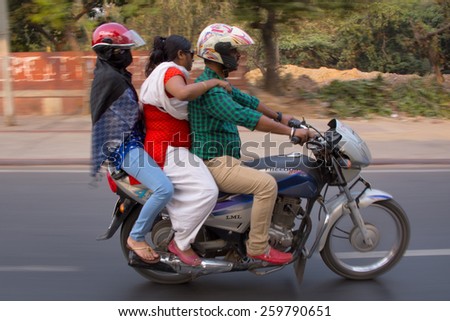 DELHI, INDIA - NOVEMBER 5: Unidentified people ride motorcycle (blurred motion) on November 5, 2014 in Delhi, India. Motocycles and motorbikes are popular mode of transportation in Delhi