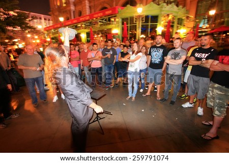 LAS VEGAS, USA - MARCH 19: Unidentified people watch street magician at night on March 19, 2013 in Las Vegas, USA. Las Vegas is one of the top tourist destinations in the world.