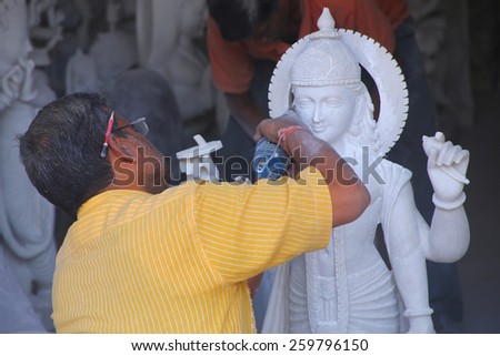 DELHI, INDIA - NOVEMBER 6: Unidentified man works  on a statue at a workshop on November 6, 2014 in Delhi, India. Delhi is the second most populous city in India.