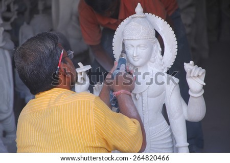 DELHI, INDIA - NOVEMBER 6: Unidentified man works on a statue at a workshop on November 6, 2014 in Delhi, India. Delhi is the second most populous city in India.