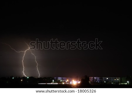 Lightning stroke in storm weather on city suburb