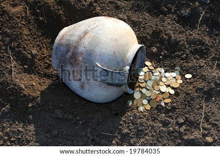 Scattered coins from the ancient jug laying on the earth