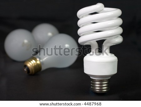 Energy saver compact fluorescent light bulb with inefficient incandescent bulbs in the background