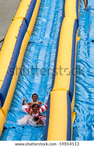 GRAND RAPIDS, MI- AUG 21: Unidentified children from the Grand Rapids area ride the 500-foot inflatable water slide at Lyon street hill on Aug 21, 2010 in Grand Rapids, MI.