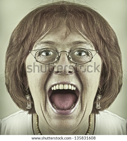 Portrait of a old woman in glasses screaming.