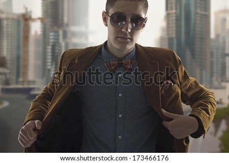 Young man in elegant suit and sunglasses in city