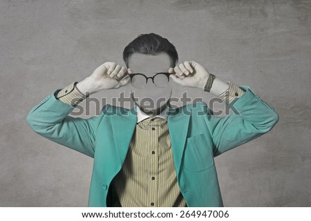 Art Photo of a young man without a face. Green suit and glasses. Hipster.