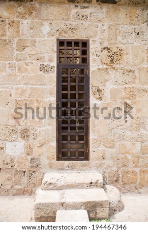 closed wooden grill door on ancient wall