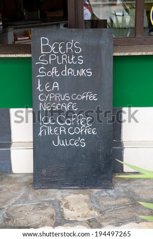 drinks list on black chalkboard in street cafe