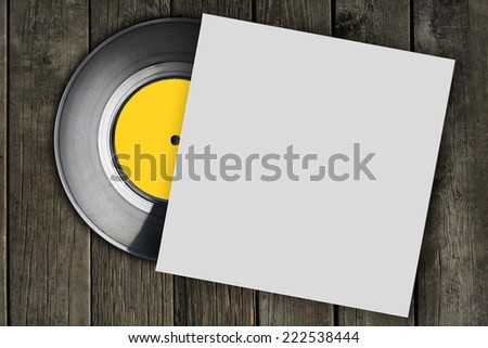vinyl record with plain white packaging on wood surface