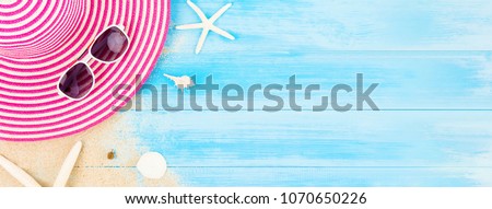 Colorful summer holiday beach banner background with accessories on light blue wood panel, border design on top view with copy space