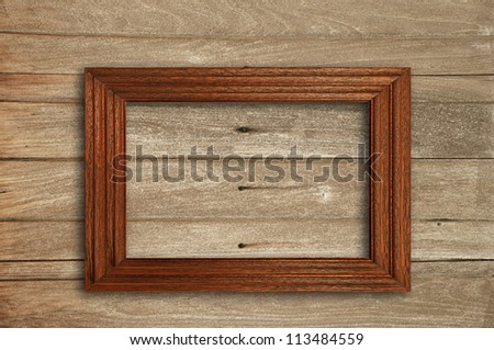Wooden picture frame on old wooden wall