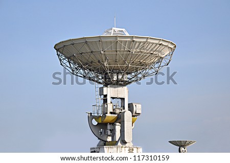 Big white satellite dishes on blue sky background