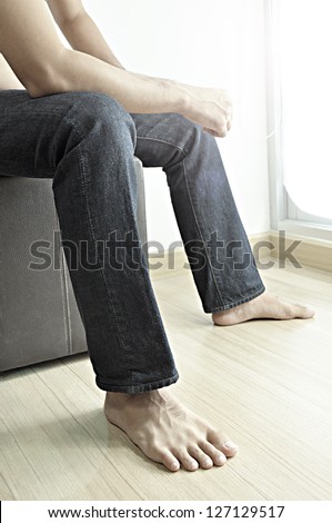 Man wearing jeans sitting on stool