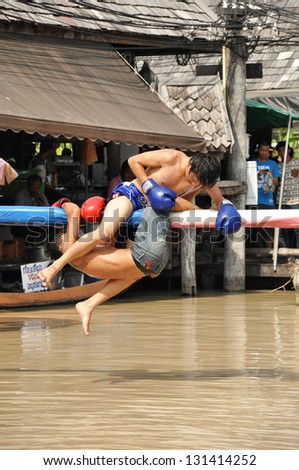 PATTAYA, THAILAND - MAR. 2 : traditional water Thai boxing (or Muay Talay) - ancient Thai fight above the water - at Pattaya floating market, Thailand  on Mar 2, 2013.