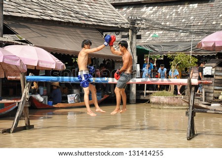 PATTAYA, THAILAND - MAR. 2 : traditional water Thai boxing (or Muay Talay) - ancient Thai fight above the water - at Pattaya floating market, Thailand  on Mar 2, 2013.