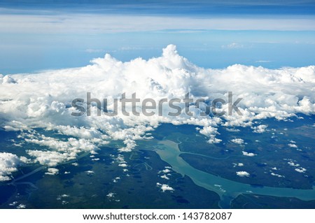 Aerial view of cloudy sky, river and forest