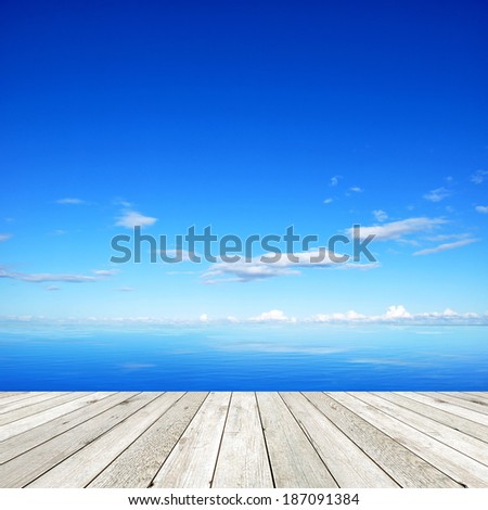 Wooden pier on blue sea and sky background